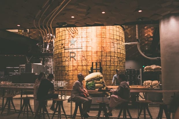 Customers sit at a coffee bar at the Starbucks Reserve Roastery in Shanghai