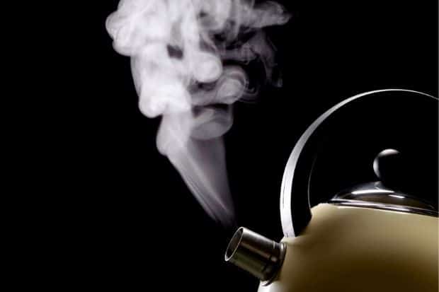 Steam coming out of boiling kettle of water for the perfect coffee brewing temperature